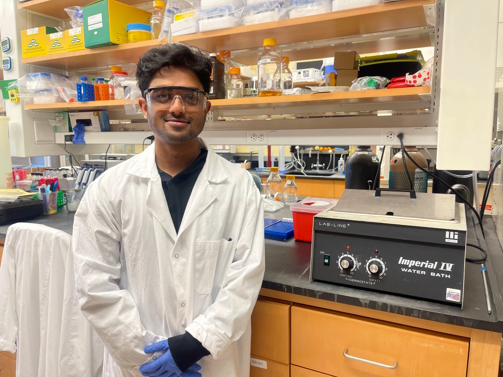 Student standing in research lab.