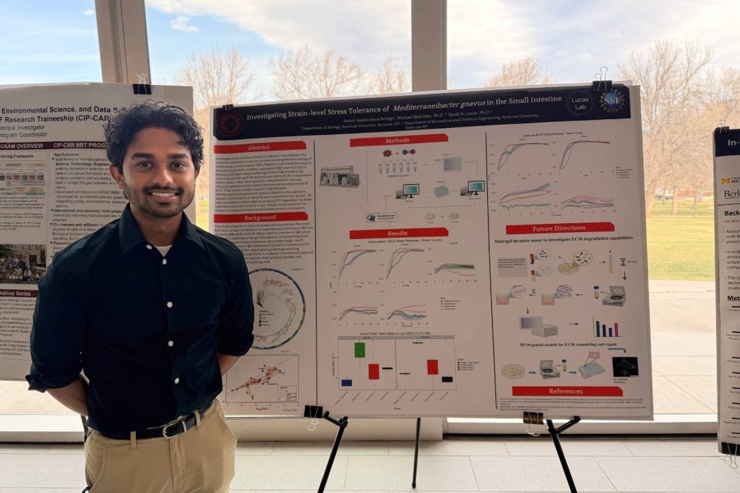 NRT Student standing in front of research poster.