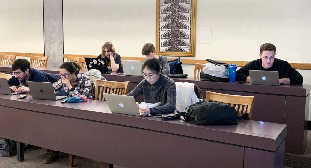 Graduate students work on their computers during a graphic design workshop