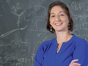 Professor Lisa Manning in front of a chalk board