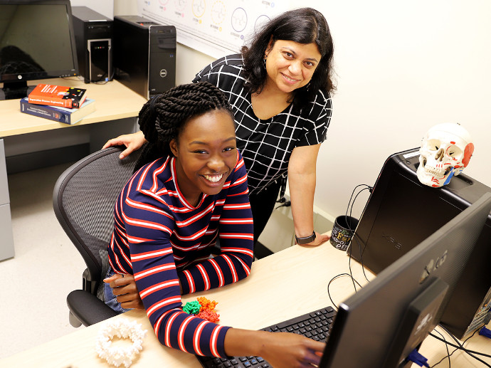 Professor Nangia and one of her students working on a computer.