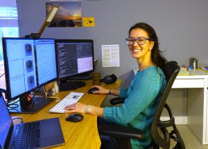 Postdoctoral associate Paula Sanematsu performing work at a computer