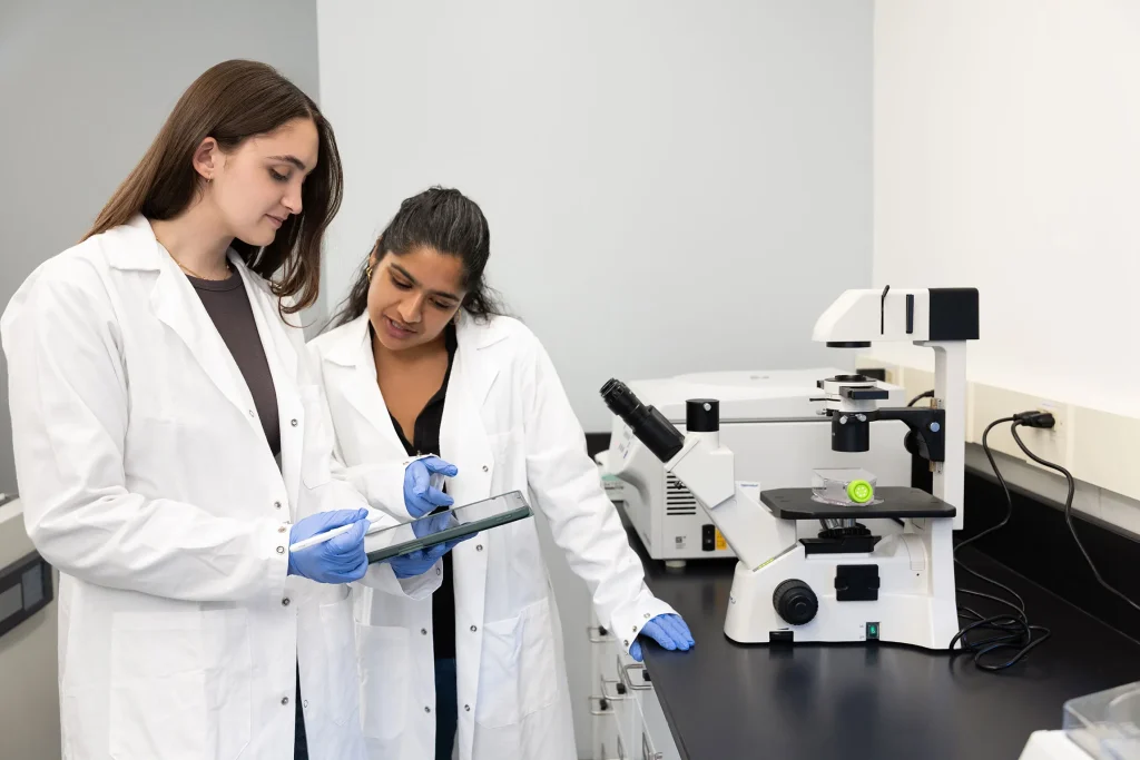 Sadie and Andrea Joseph in lab looking at iPad
